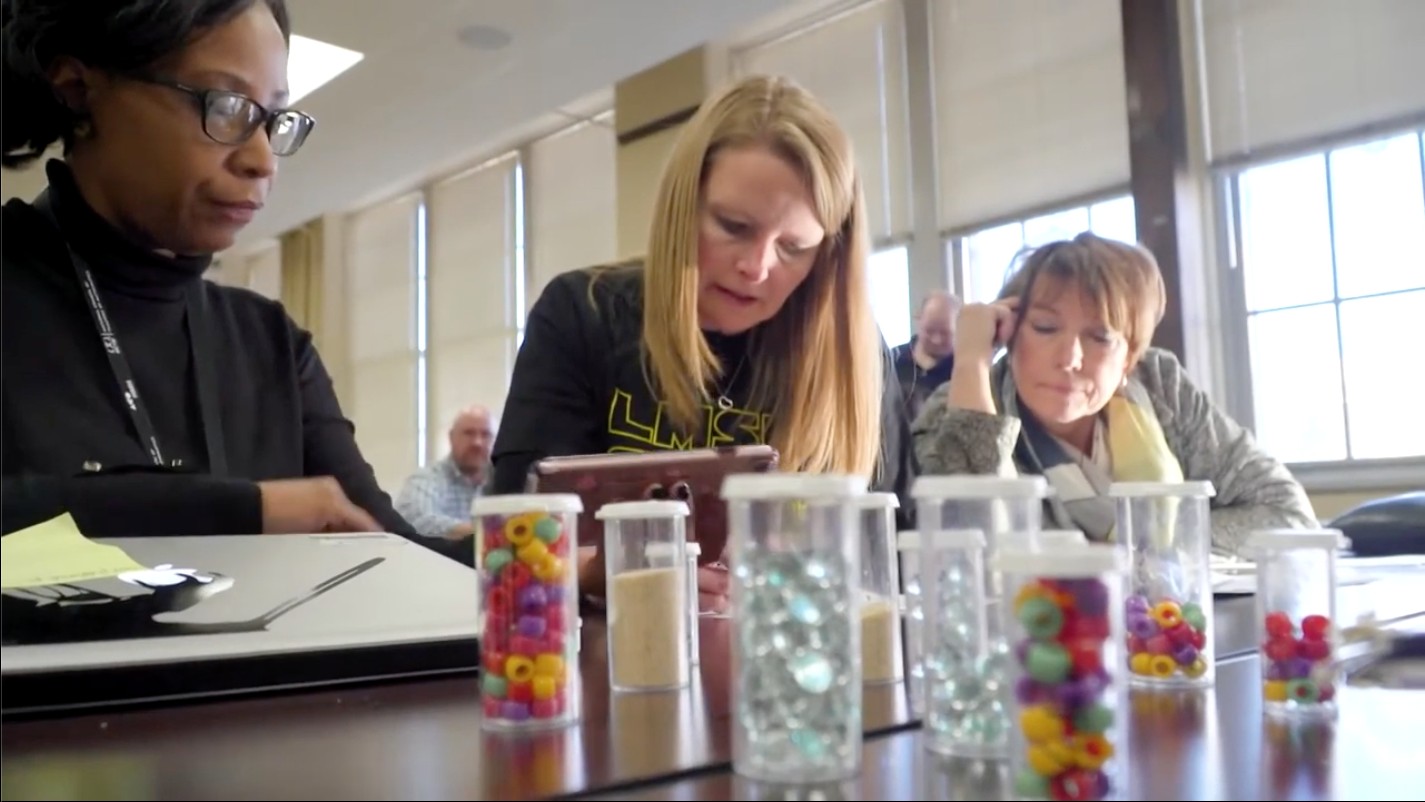 Three Arcadia STEM Education students work on a project with beads