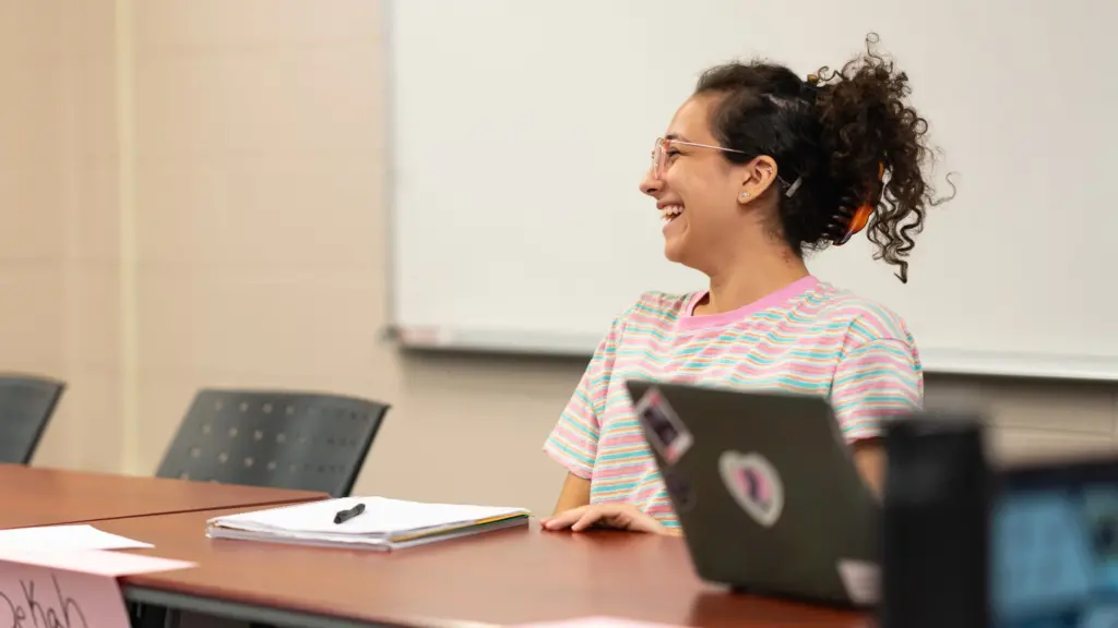 A grad student laughs in class