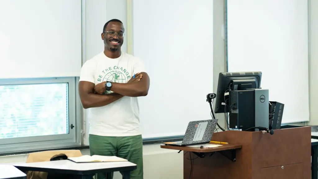 A professor smiles while teaching a graduate class