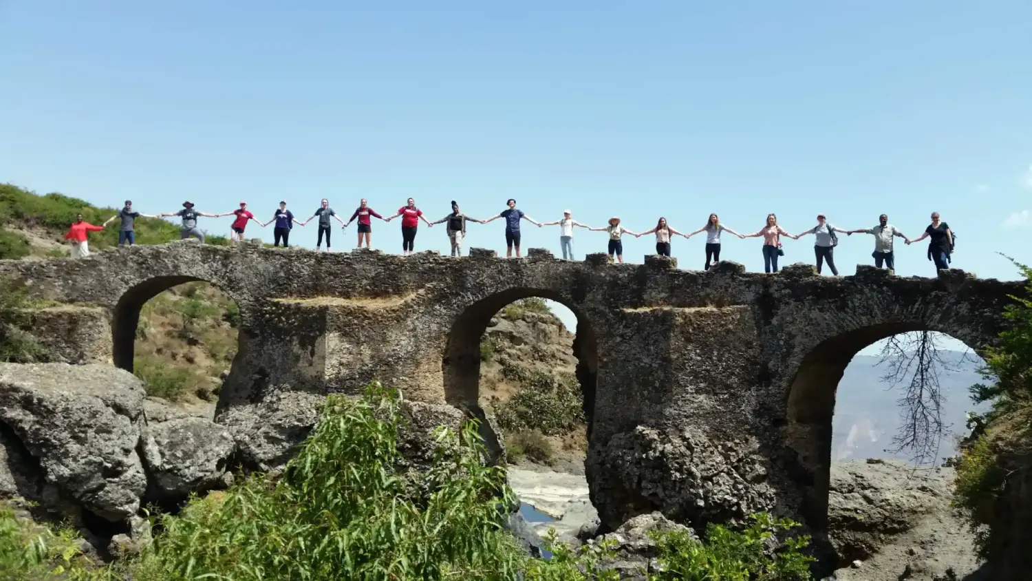 Students stand arm to arm on a stone bridge in Ethiopia.