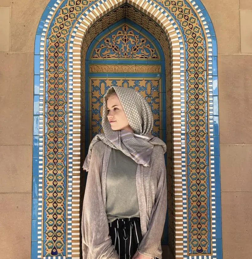An Arcadia student poses in front of religious tiles overseas.