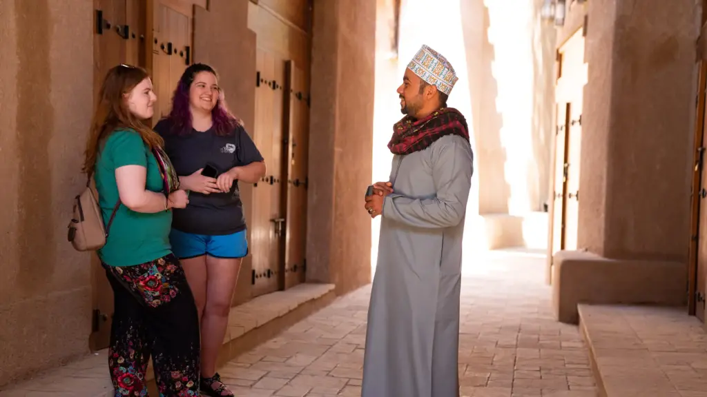IPCR students talk to a man in traditional dress in the Middle East.