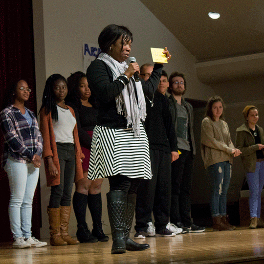 Honors students join a speaker on stage while they talk to an audience.