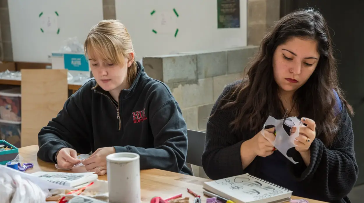 Two honors students cut out a craftivism project.