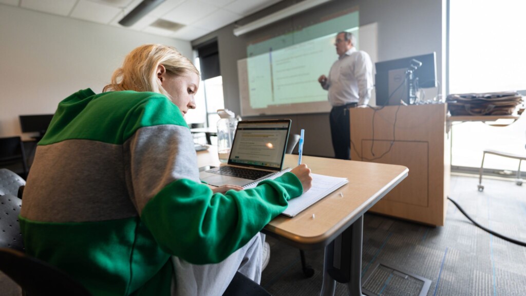 A student takes notes in a Business Admin class.