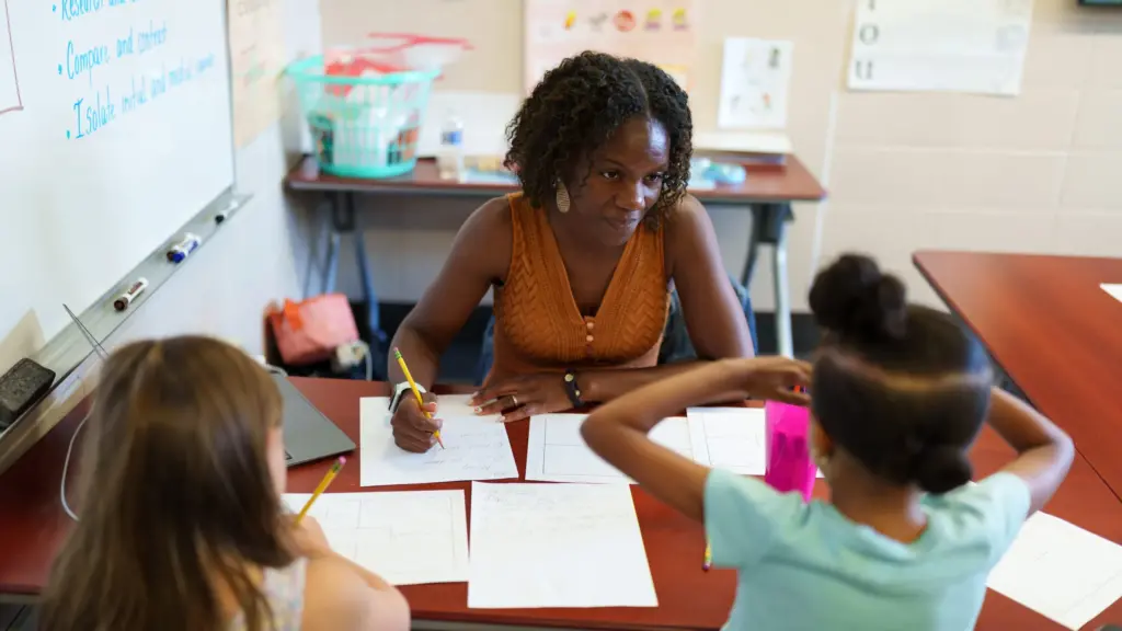 A student teacher instructs children in a literacy seminar.