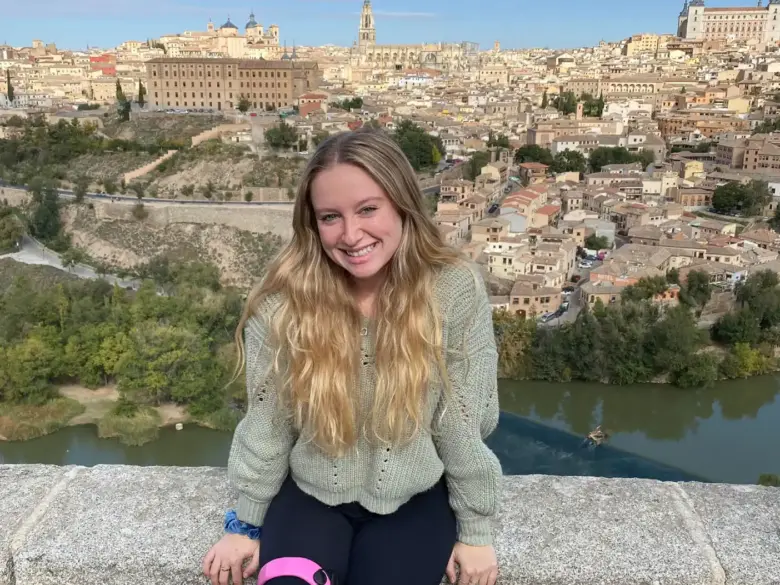 Compass editor in chief Madeline Lynch by a river landscape view in Europe.