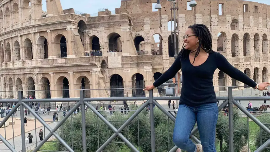 An Arcadia student poses in front of a ruin in Italy