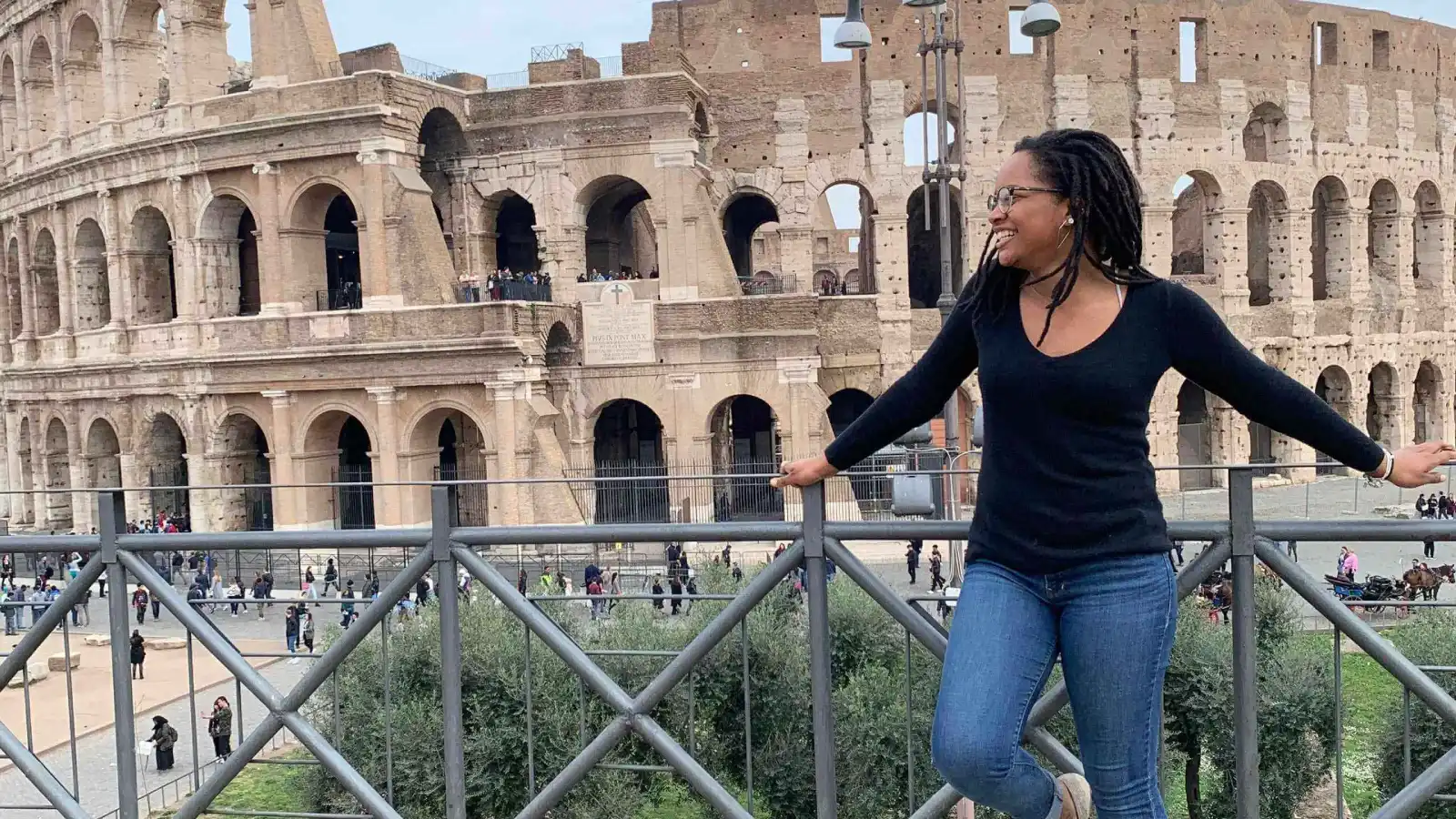 An Arcadia student poses in front of a ruin in Italy