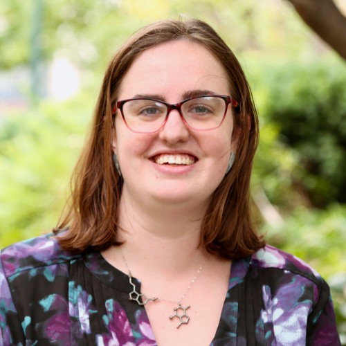 Portrait of woman wearing black and purple shirt and glasses