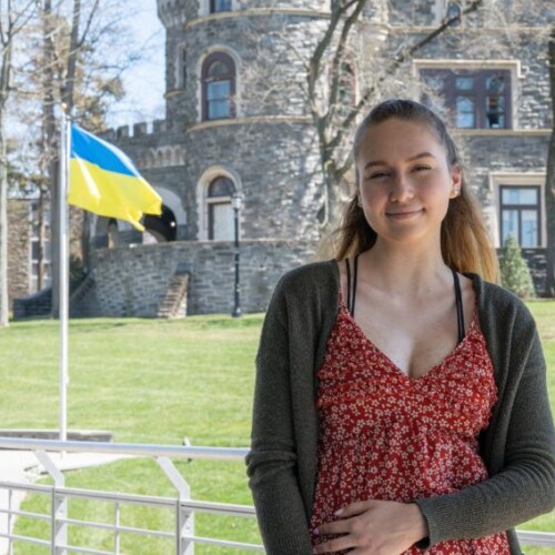 Victoria Fedorko outdoors with US and Ukraine flags behind her