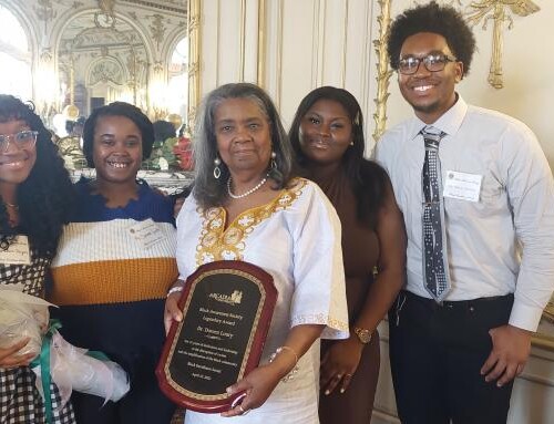 Arslie Jacques-Louis ‘24, Simone Smith ‘23, Dr. Loury, Nyla Russel ’24, and O'Shane Mendez ’24 posing together with a plaque and flowers