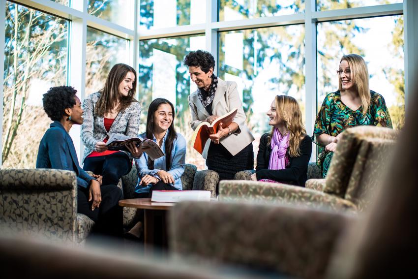 Six people, some with open books, communing in an indoor lounge area