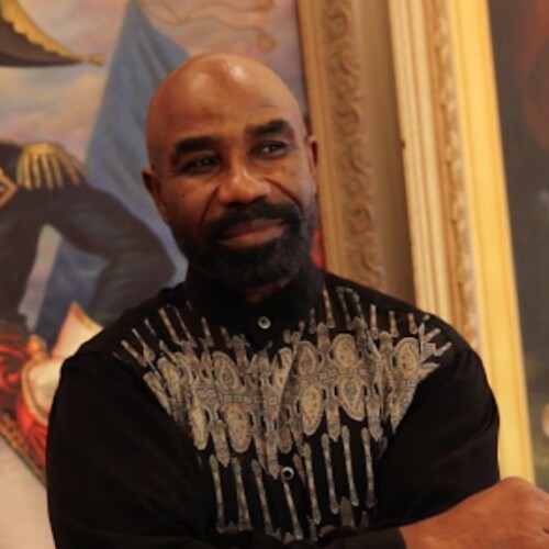Haitian American artist Ulrick Jean-Pierre with painted artwork around him