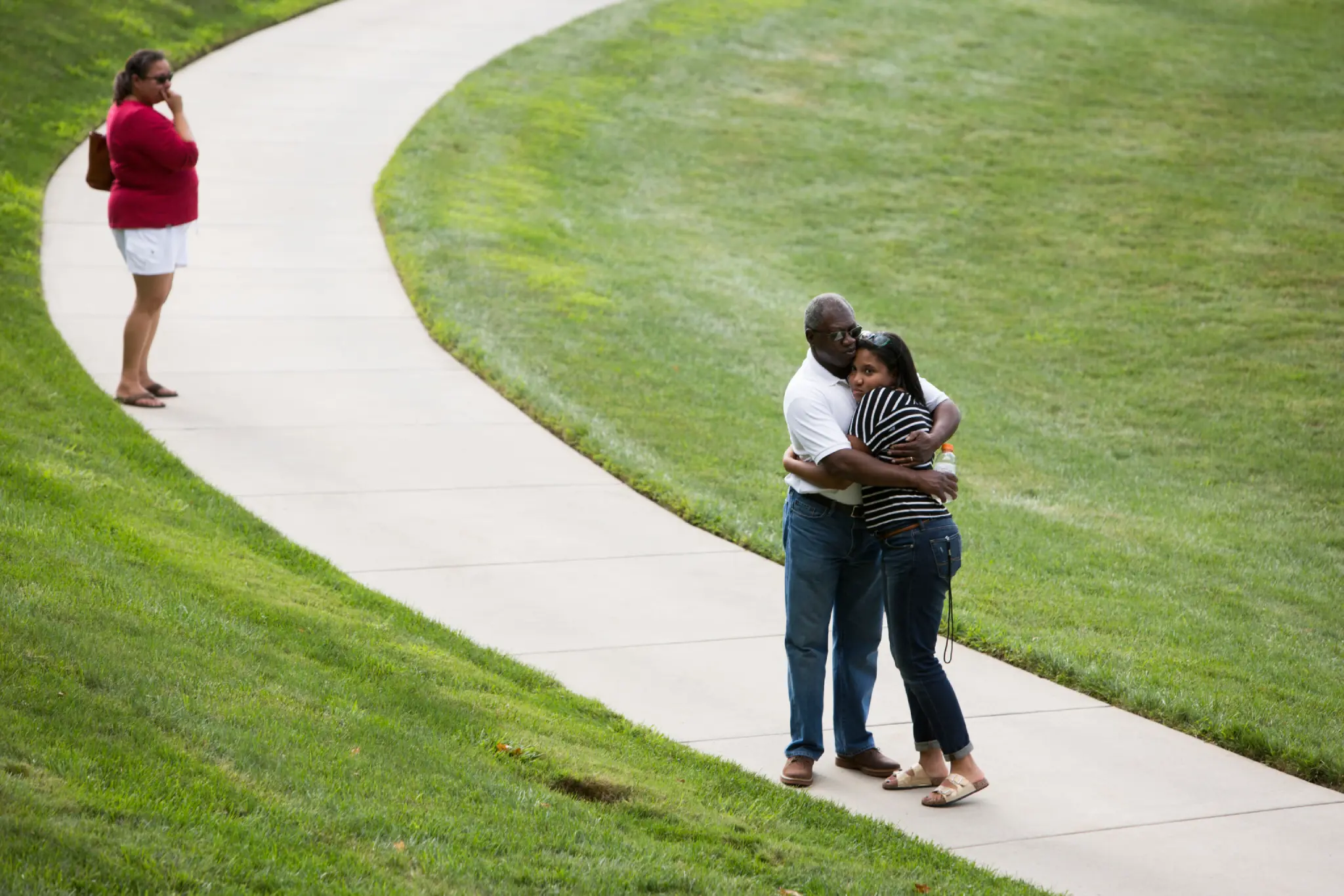 Student hugs parents outside on move-in day.
