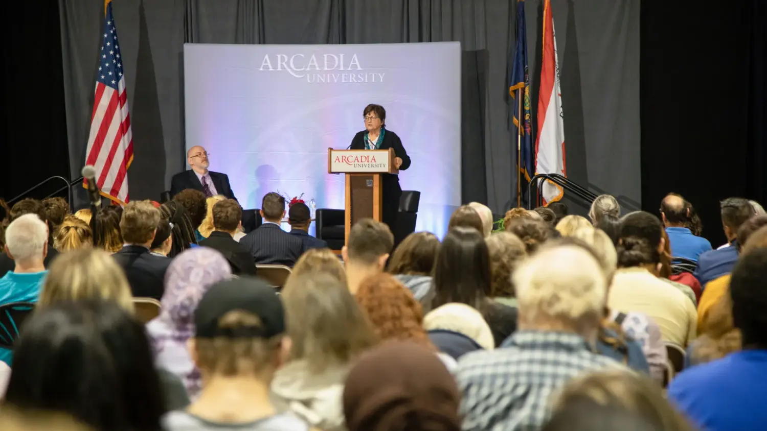 Sister Helen speaking at a podium about the common reads book