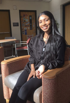 A girl sitting on a chair, smiling at the camera