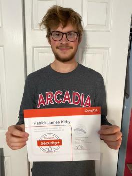 A student holding a certificate for computer security