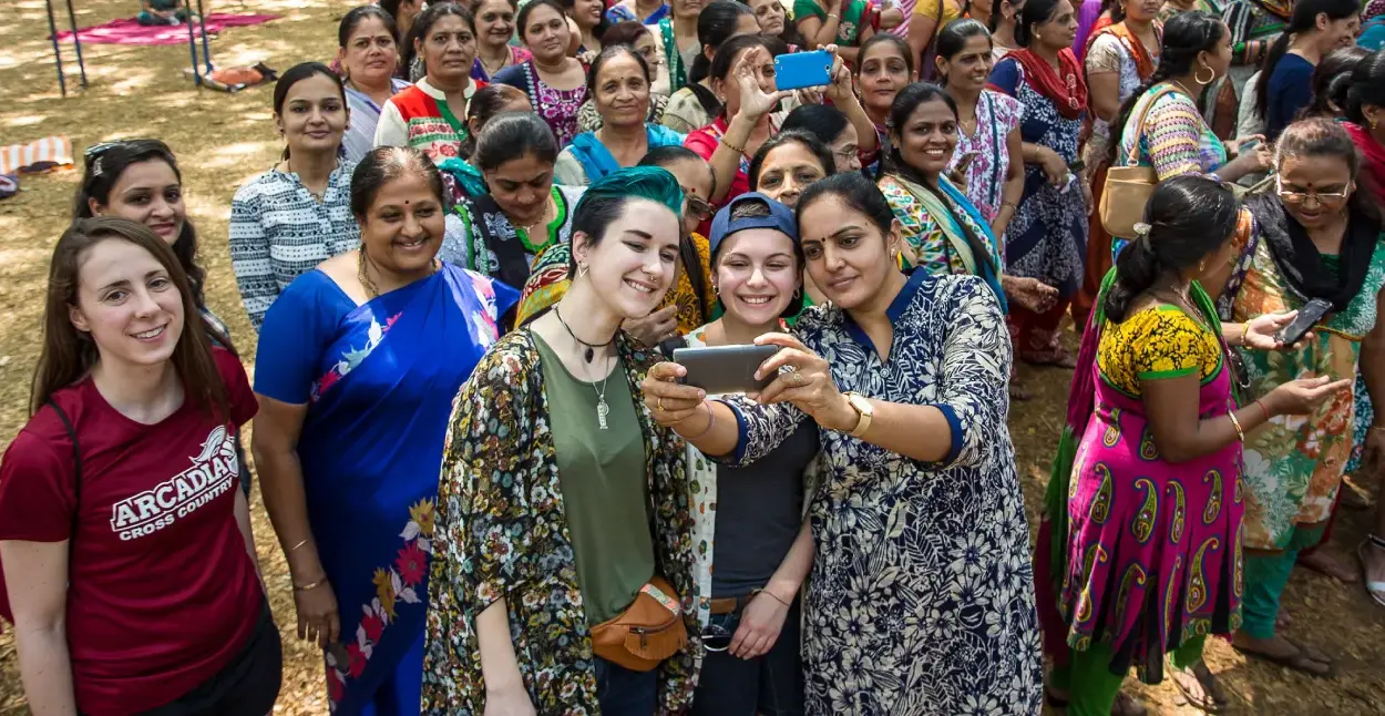 Students taking a selfie with people they are visiting in India.
