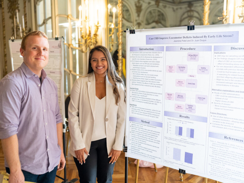 Professor Logan Fields and a student stand by a capstone poster.