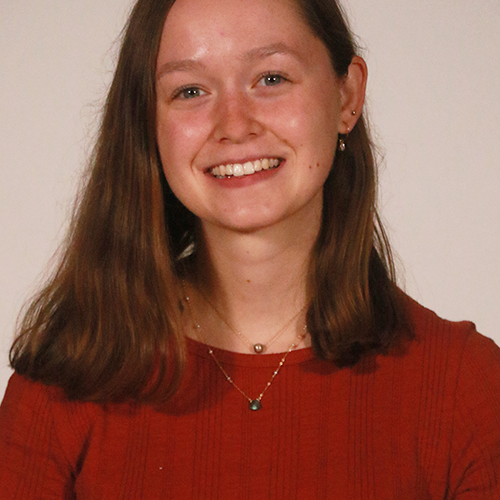 A headshot of Nicole Ducray '24 wearing a red short-sleeved blouse