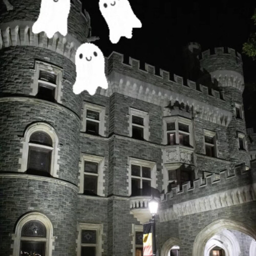 Grey Towers Castle at night with ghost cartoons on top