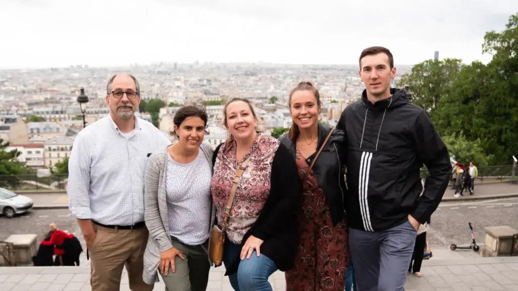 Five people stand in front of the beautiful and inspiring Parisian skyline.