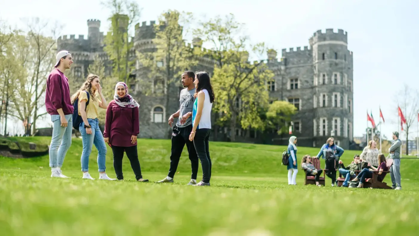 Students gather on Haber Green with the castle in the background.