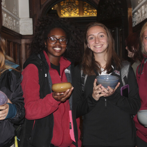 Four students show off their ceramic bowls during the Empty Bowl event.