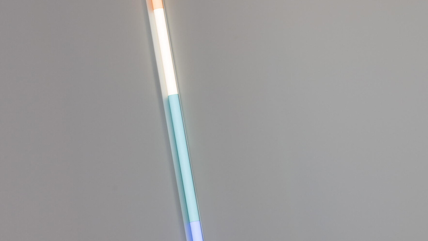 a sculpture consisting of a tube shaped light with sections corresponding to each color in roygbiv