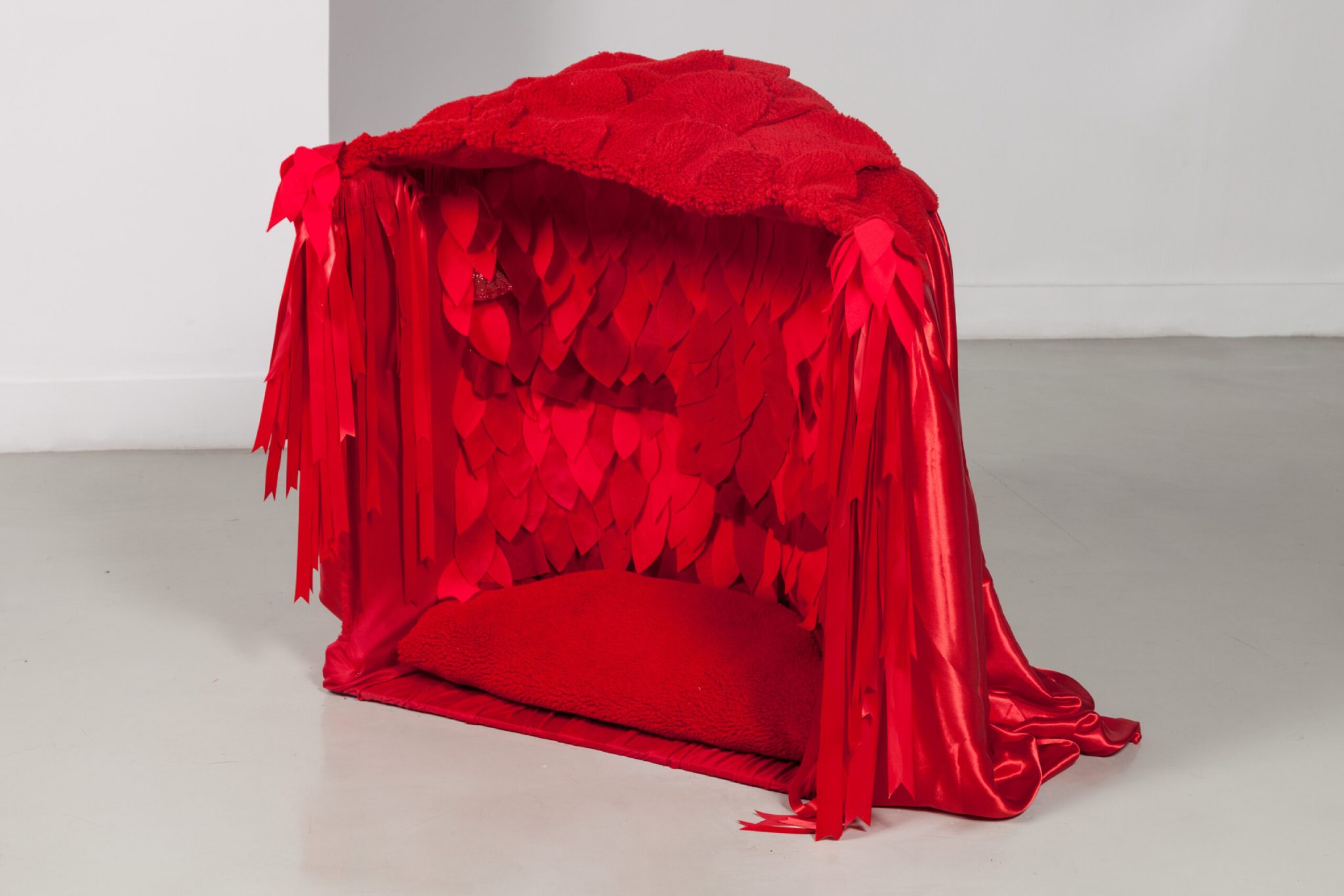 An exhibition showing a red fabric like structure