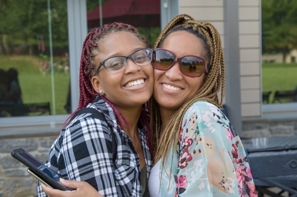 A mother and daughter hugging and smiling into the camera during move in at Arcadia campus