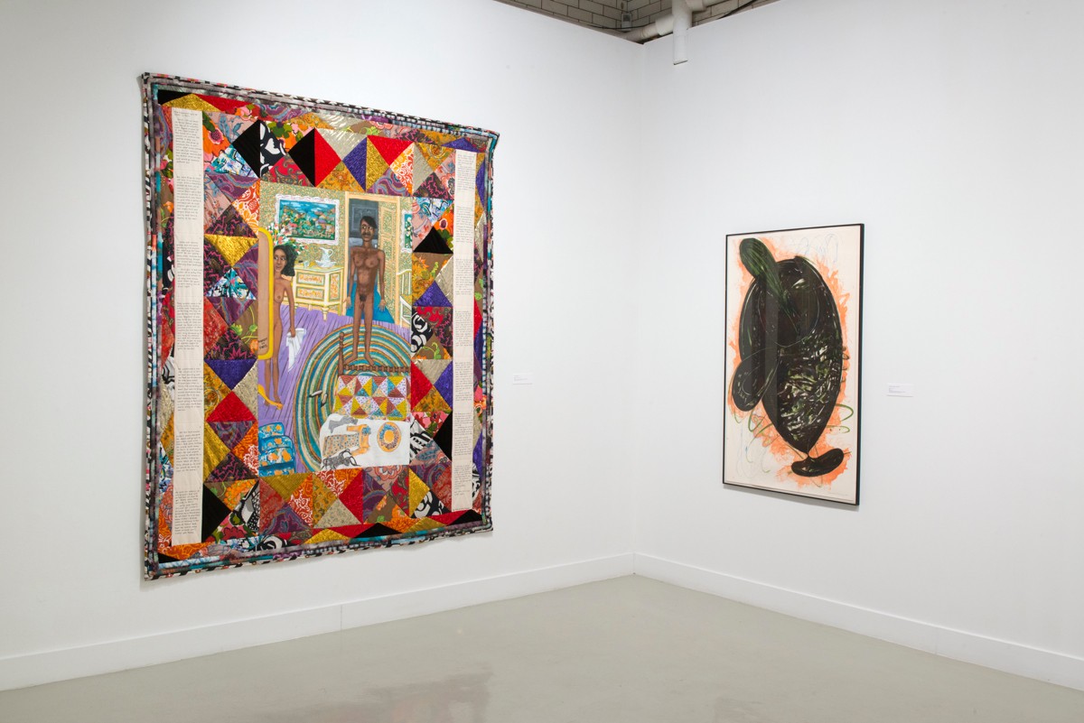 Installation view from "Threading the Maze" with two panels; a large colorful polygonal mural and a smaller organic abstract piece in black, white, and coral.
