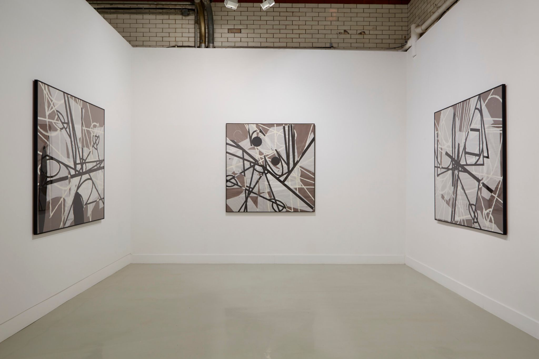 Installation view from "Coordinates: Drawings and Prints Marking Five Exhibitions at Beaver College (1977-84)" with three panels featuring monochromatic geometric designs in white, black, and brown.