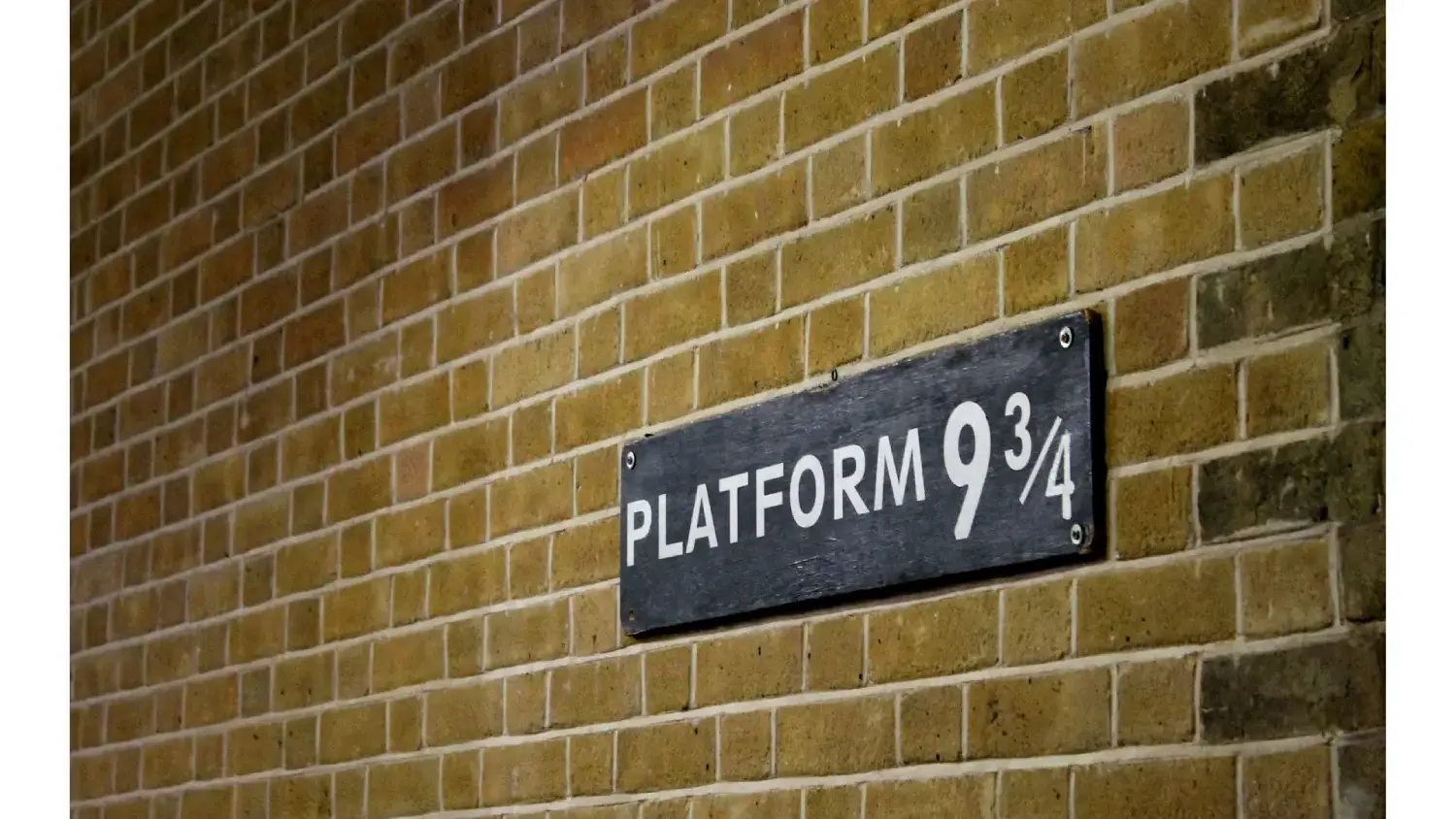 a sign that reads platform 9 3/4 on a brick wall