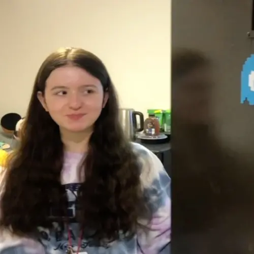 a student named Veronica looks out from the door of her residence hall