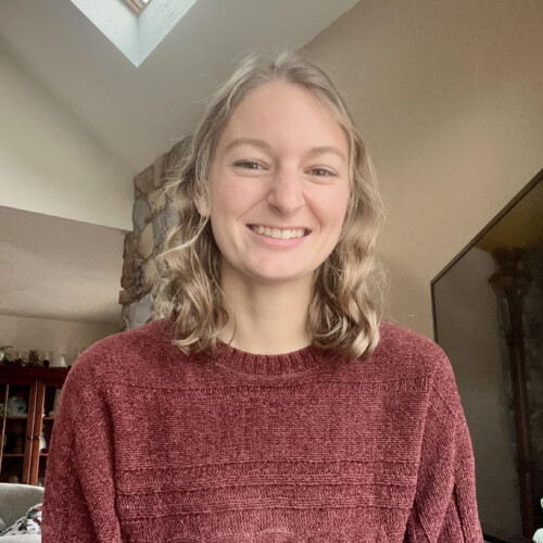 Morgan Glista '23 wearing a red sweater and smiling