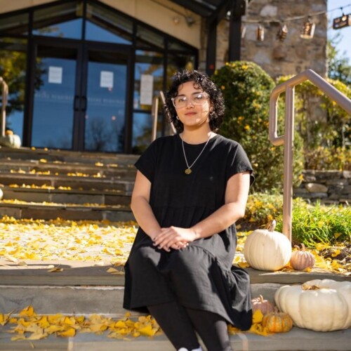 Bryanna Martinez-Jiminez '22 sits in front of People's Light theater on a Fall day.