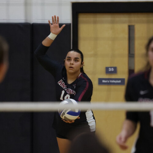A women's volleyball player gets ready to serve the ball
