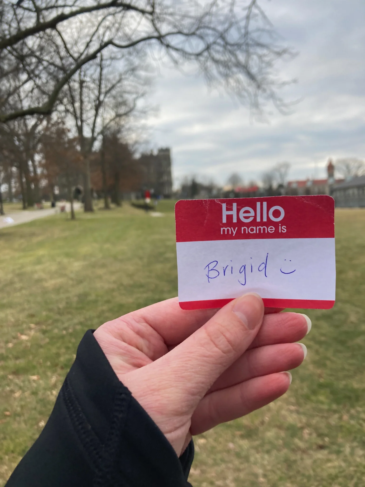 A name tag held in front of Haber Green that says "Hello my name is Brigid"