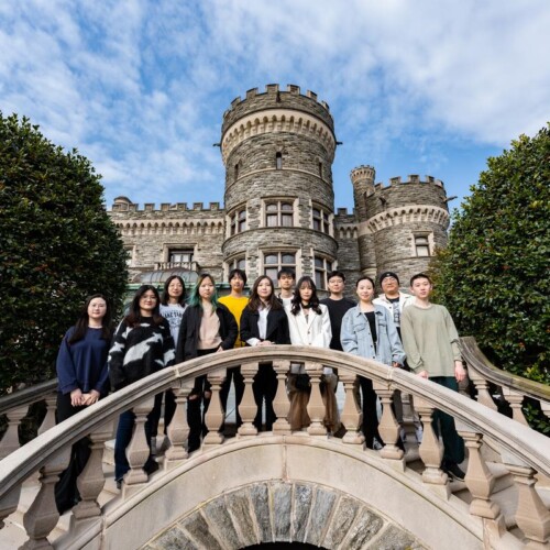 A portrait of 12 students outside the castle, Arcadia's 2023 graduates of the Jiangsu University program