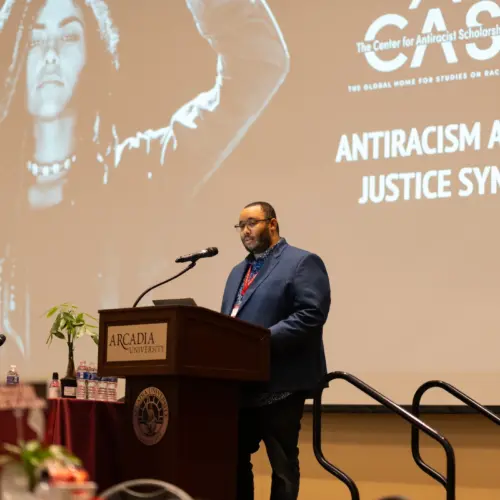 A speaker on podium at the CASAA Antiracism and Social Justice Symposium event