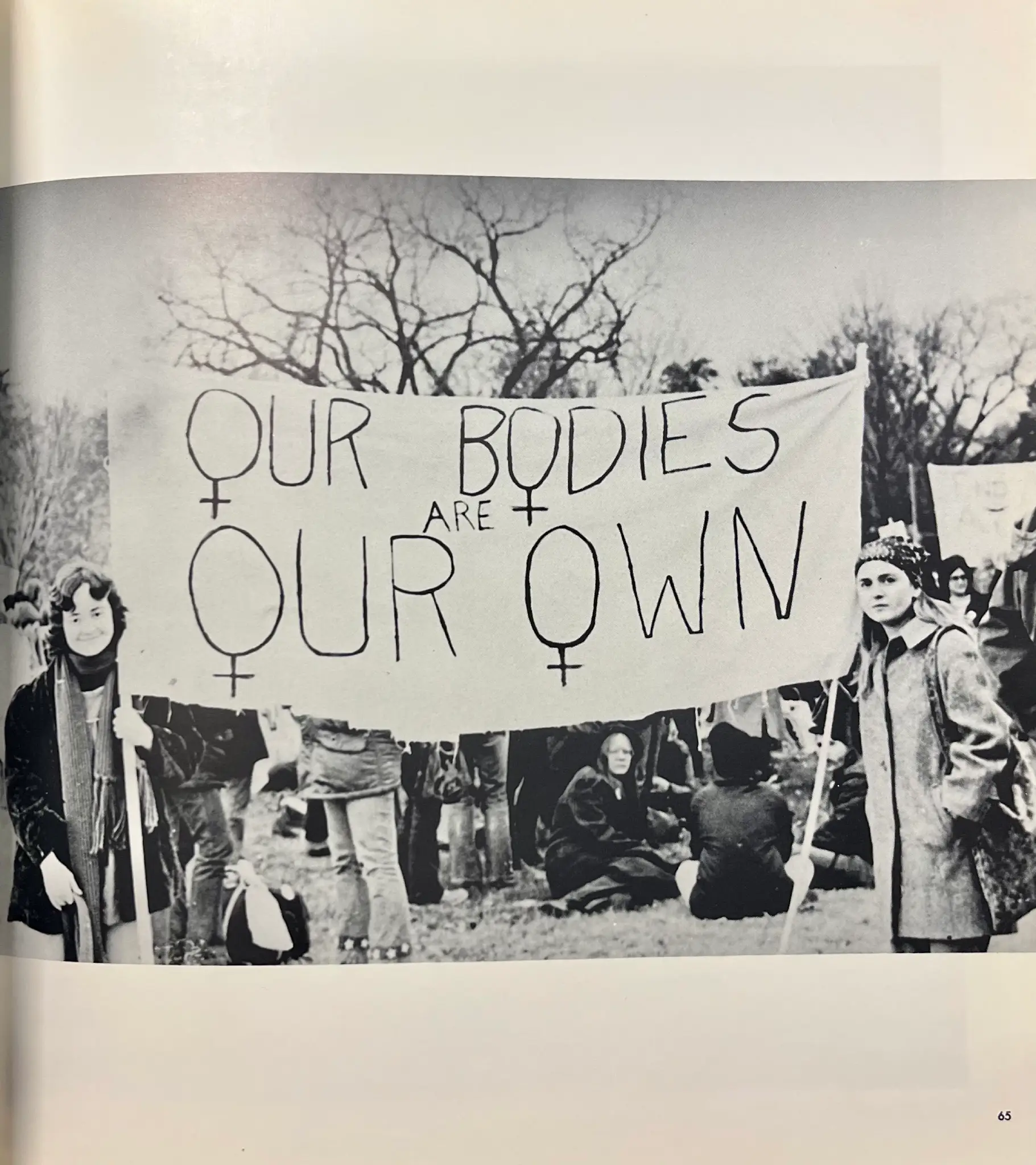 Two women holding a banner stating "our bodies are our own".