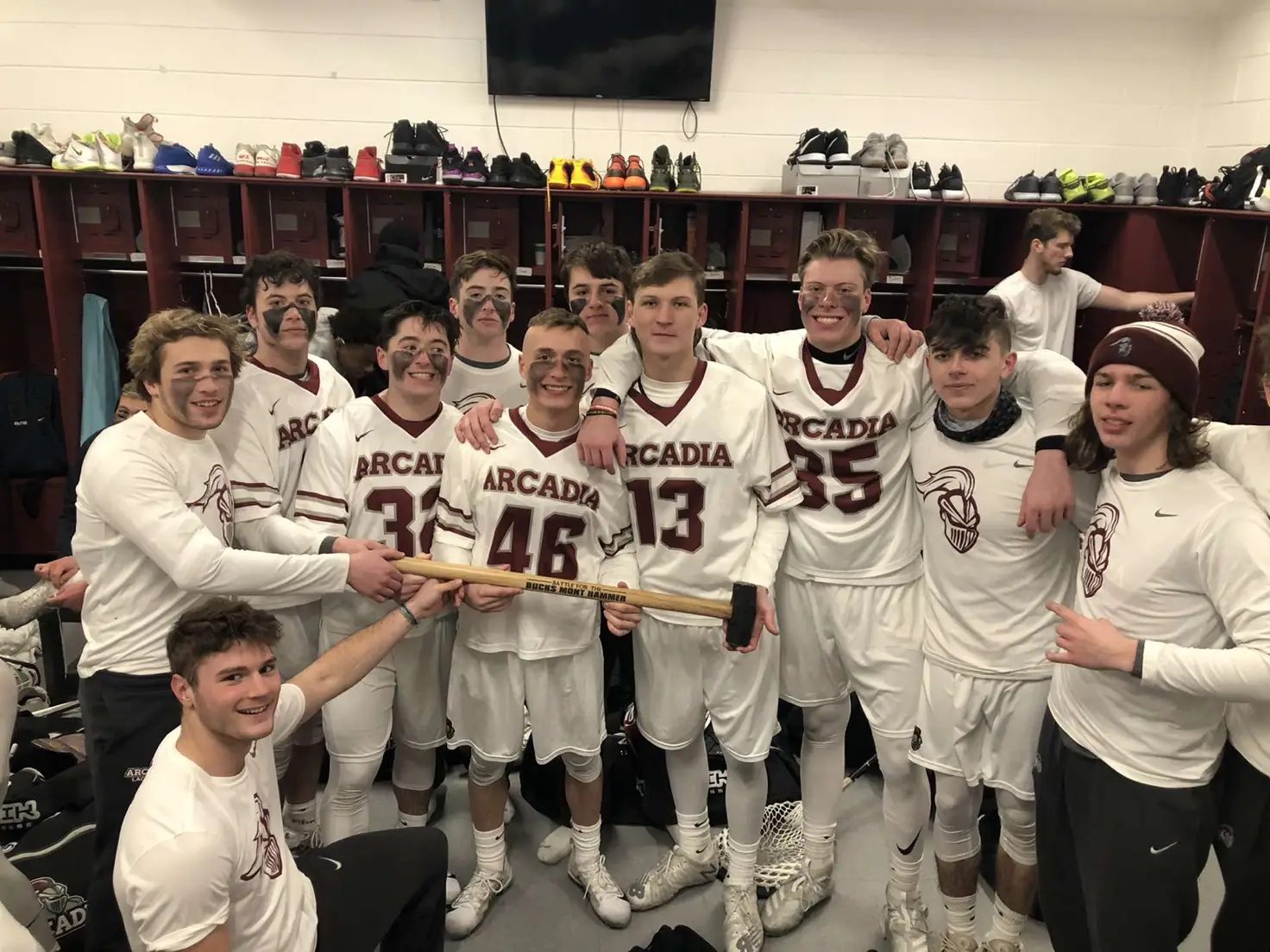 Members of the men's lacrosse team pose for a photo in the locker room