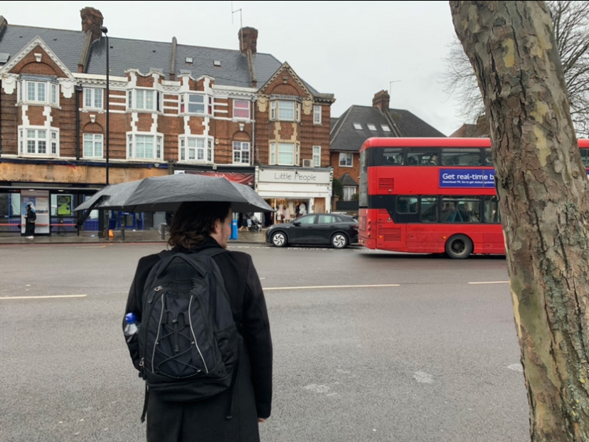 A person with their back to the camera, holding an umbrella, in London