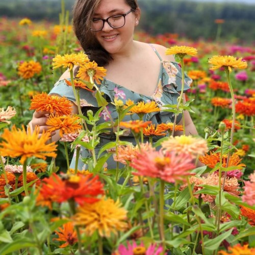Grace Lamb '27 smiling in a field of flowers.