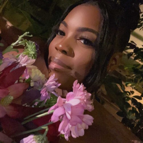 A photo of Roseanna holding flowers.