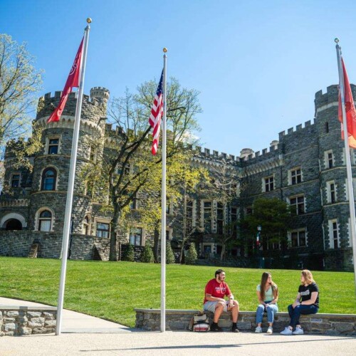 Grey Towers Castle with students sitting in front of it.