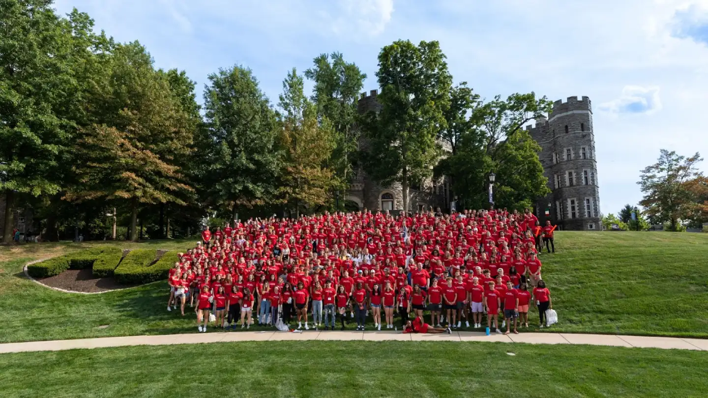 Large group of new students standing in front of Grey Castle on Haber Green during Welcome Week.