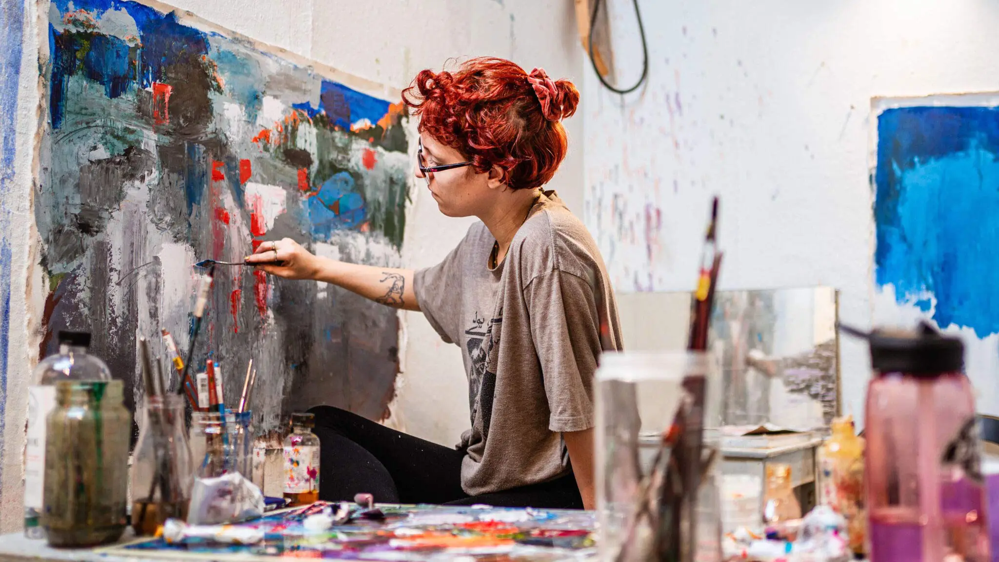 An art student works on a painting in a studio during class in Spruance Hall.